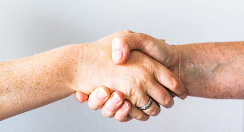 Obchodní partneri si podávajú ruky pri uzavretí spolupráce